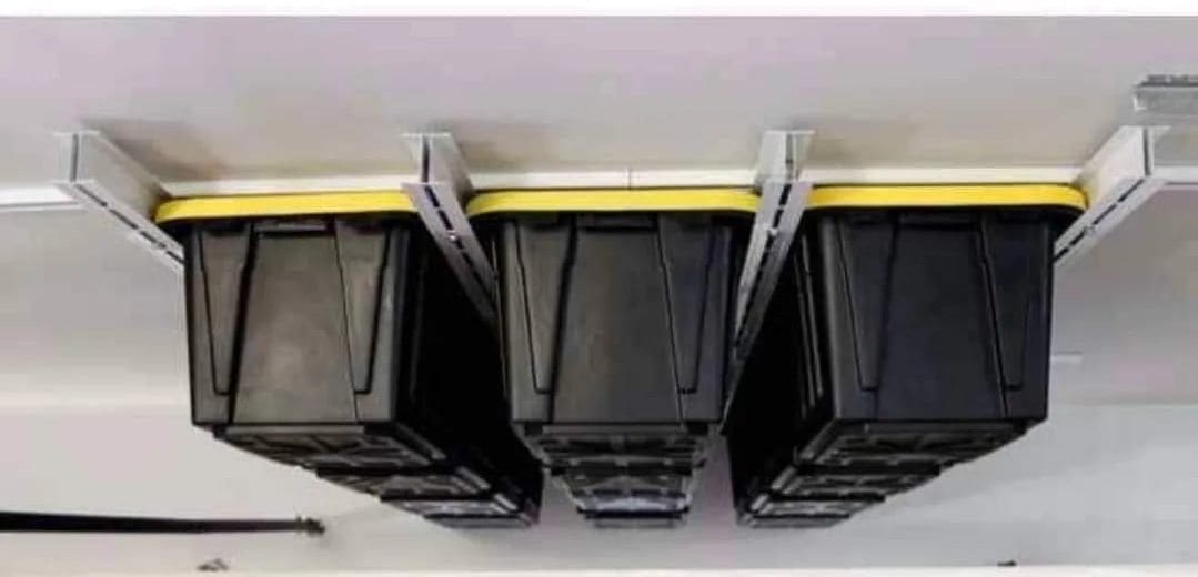 Storage totes suspended from an overhead garage rack